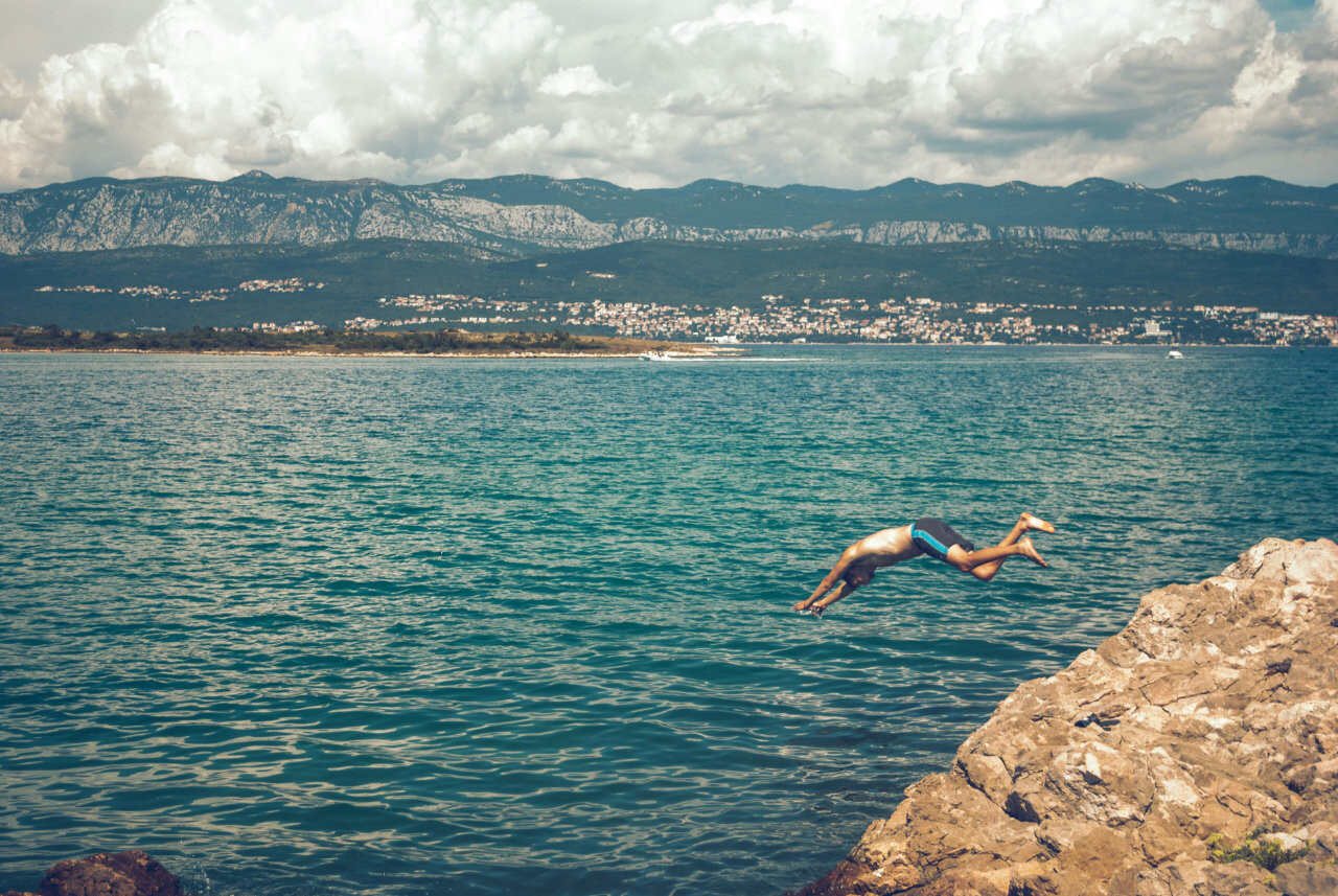 Jumping in the crystal-clear sea on Krk island.